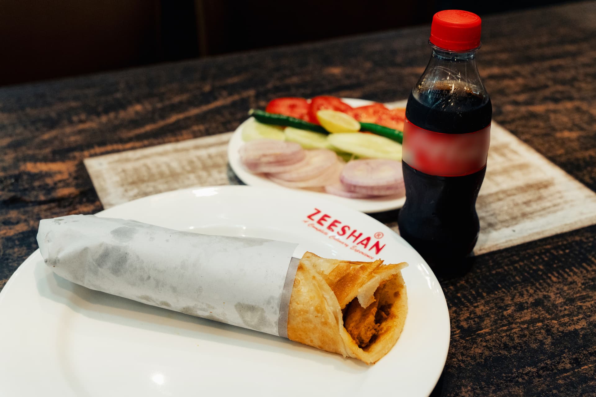 <p><em>Zeeshan always has a crowd queued outside to grab rolls to go with chilled cola drinks.</em></p>