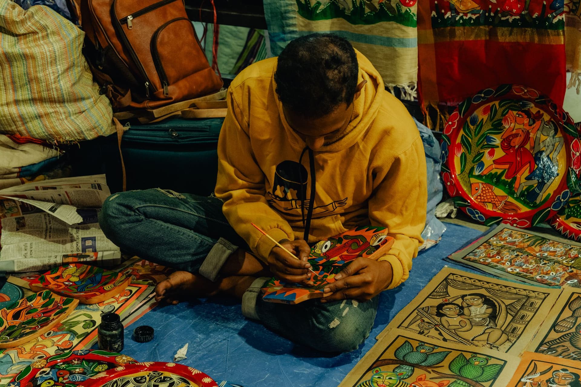 <p>An artisan putting the finishing touches to a patachitra painting.</p>