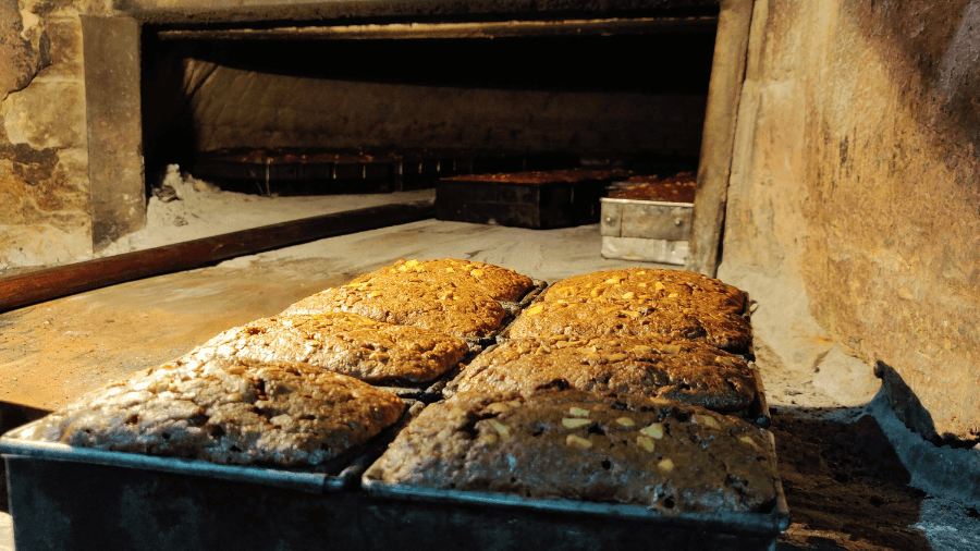 <p>Fresh plum cakes emerge from a traditional community oven — a time-honoured December ritual in Kolkata's bakeries.</p>