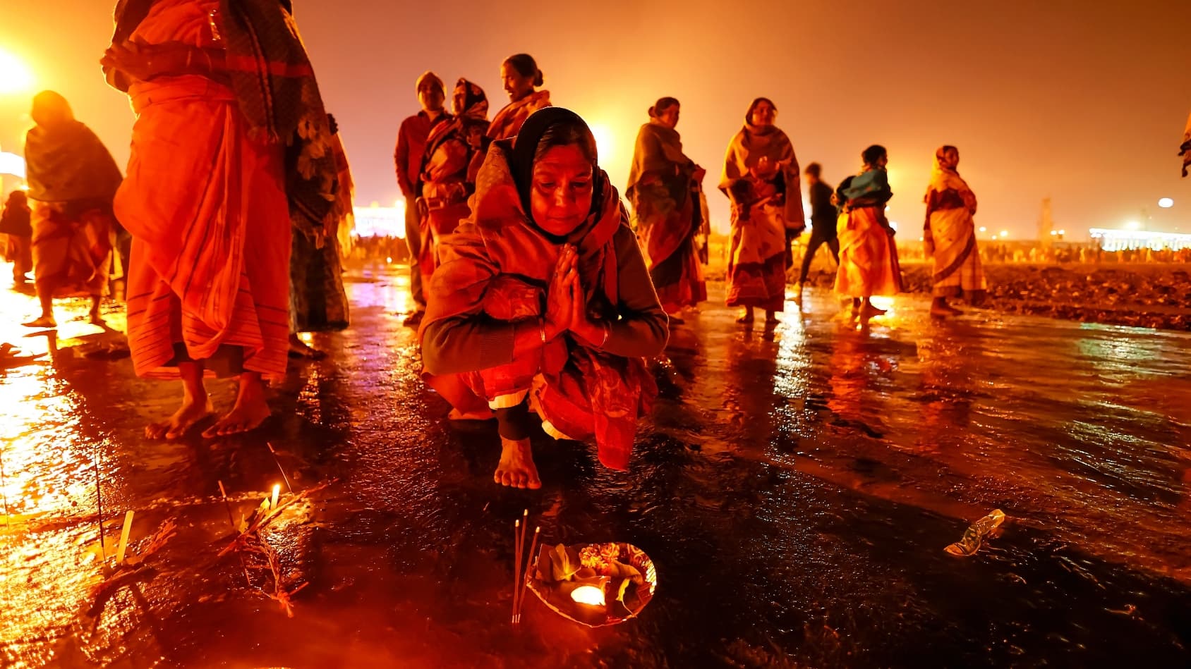 <p>A devotee offers prayers at the water’s edge. (Shutterstock)</p>