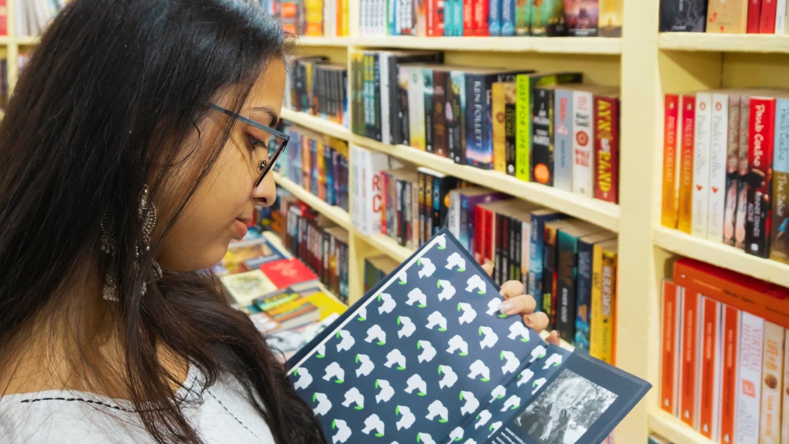 <p>A moment of discovery as a visitor examines a beautifully designed book. (Shutterstock)</p>