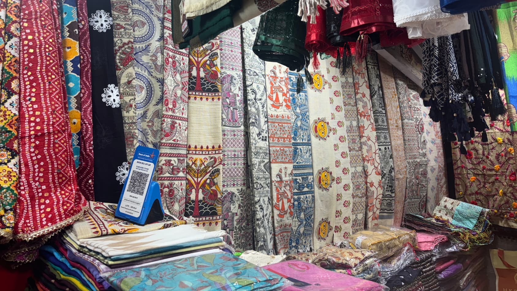 <p>Different kinds of dupattas line the walls in dense rows.&nbsp;</p>